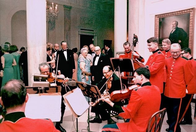 When Fortas resigned in May 1969, newspapers printed this photo taken in the foyer of the White House with LBJ, George Meany, Gerald Ford, and the rest of the Marine Strings watching quartets played by (from left) Daniel Rothmuller (back to camera, cello), Budapest String Quartet’s violinist Alexander Schneider (seated, first violin), Abe Fortas (seated, second violin), Dave Wundrow (standing, bass, making this technically a string quintet) and Alan de Veritch (seated, viola). Photo taken January 25th, 1968.